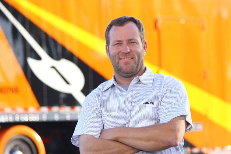 Veteran Allied Van Lines driver for Allegheny Valley Transfer standing in front of his orange truck