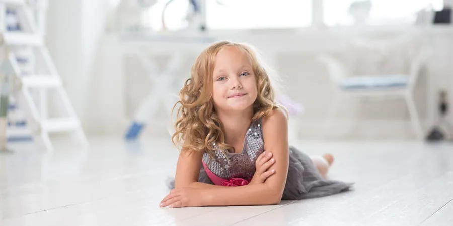 A young girl relaxing on the floor of her family’s new home after moving